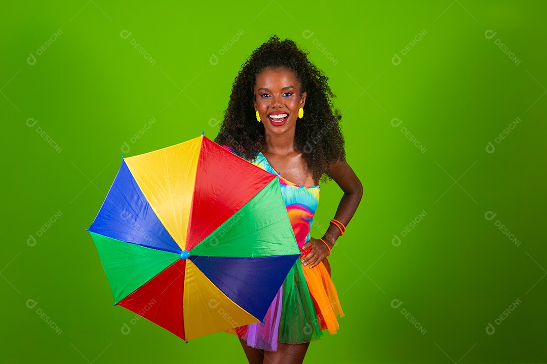 Linda morena do cabelo cacheado sorridente fantasiada segurando guarda-chuva sobre fundo verde isolado