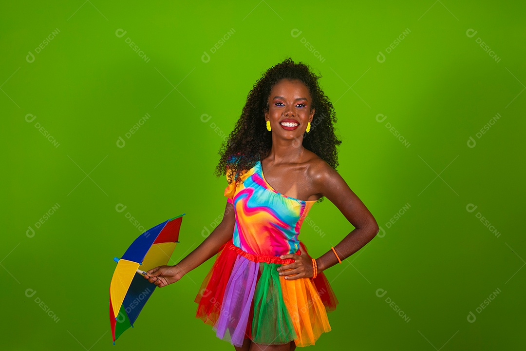 Linda morena do cabelo cacheado sorridente fantasiada segurando guarda-chuva sobre fundo verde isolado