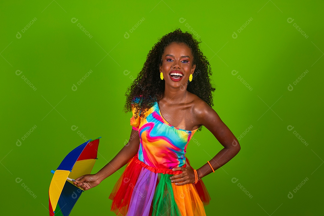 Linda morena do cabelo cacheado sorridente fantasiada segurando guarda-chuva sobre fundo verde isolado