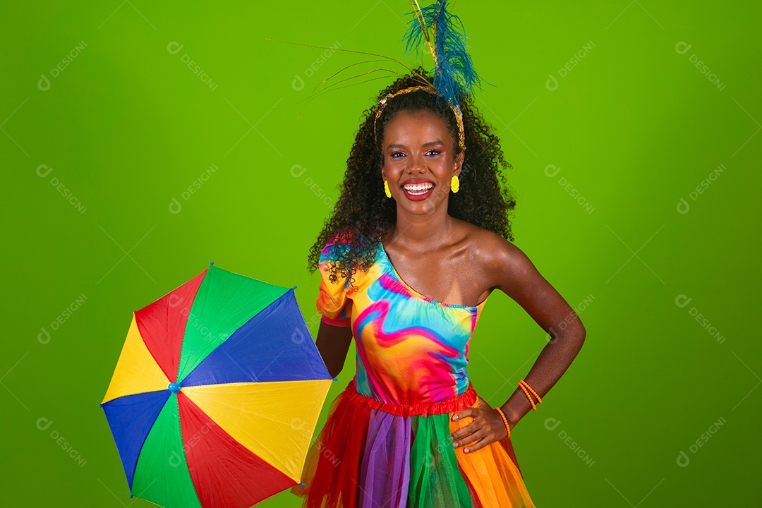Linda morena do cabelo cacheado sorridente fantasiada segurando guarda-chuva sobre fundo verde isolado