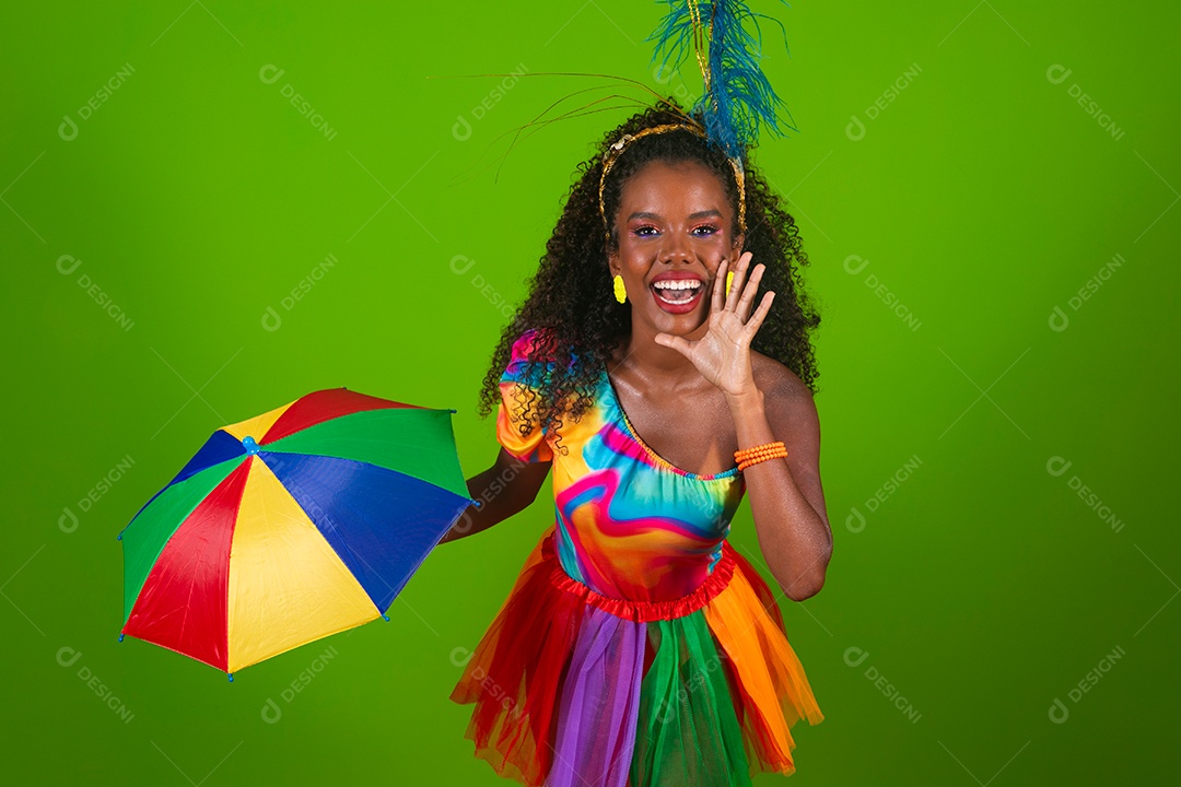 Linda morena do cabelo cacheado sorridente fantasiada segurando guarda-chuva sobre fundo verde isolado