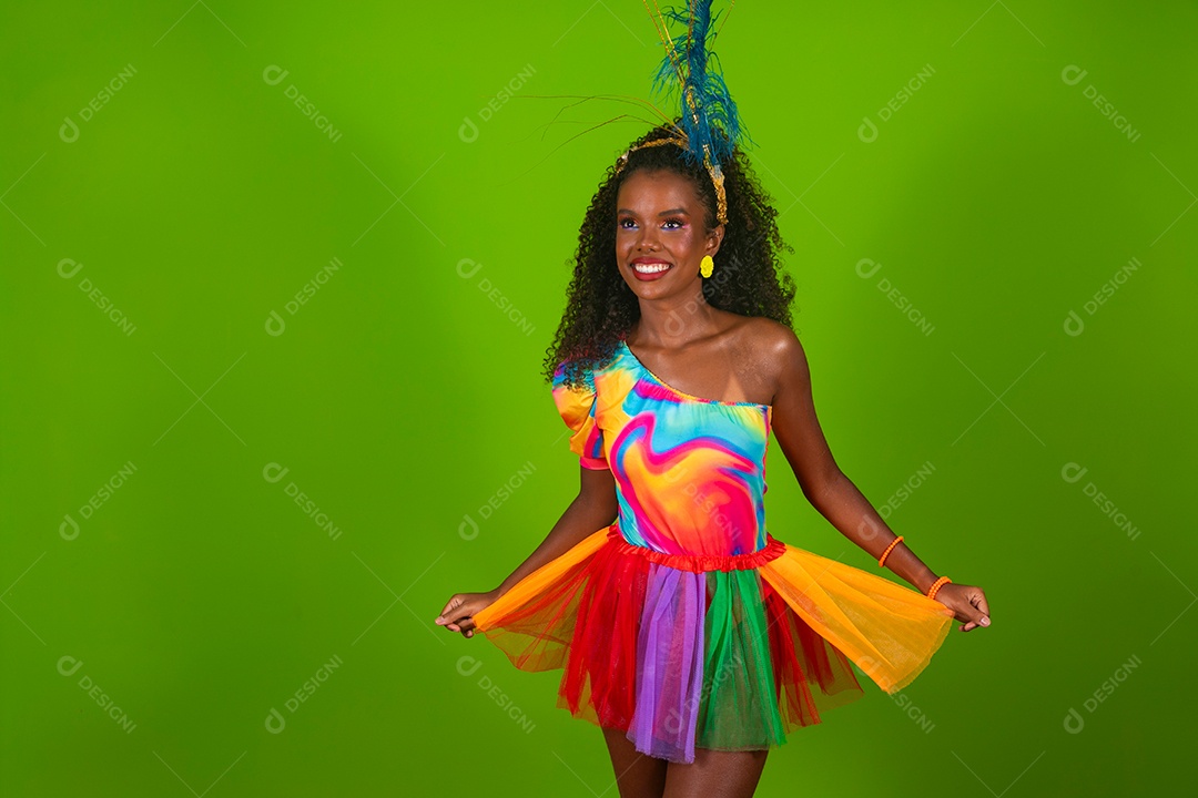 Linda morena do cabelo cacheado sorridente fantasiada sobre fundo verde isolado