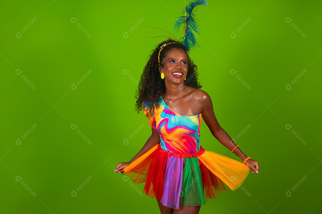 Linda morena do cabelo cacheado sorridente fantasiada sobre fundo verde isolado