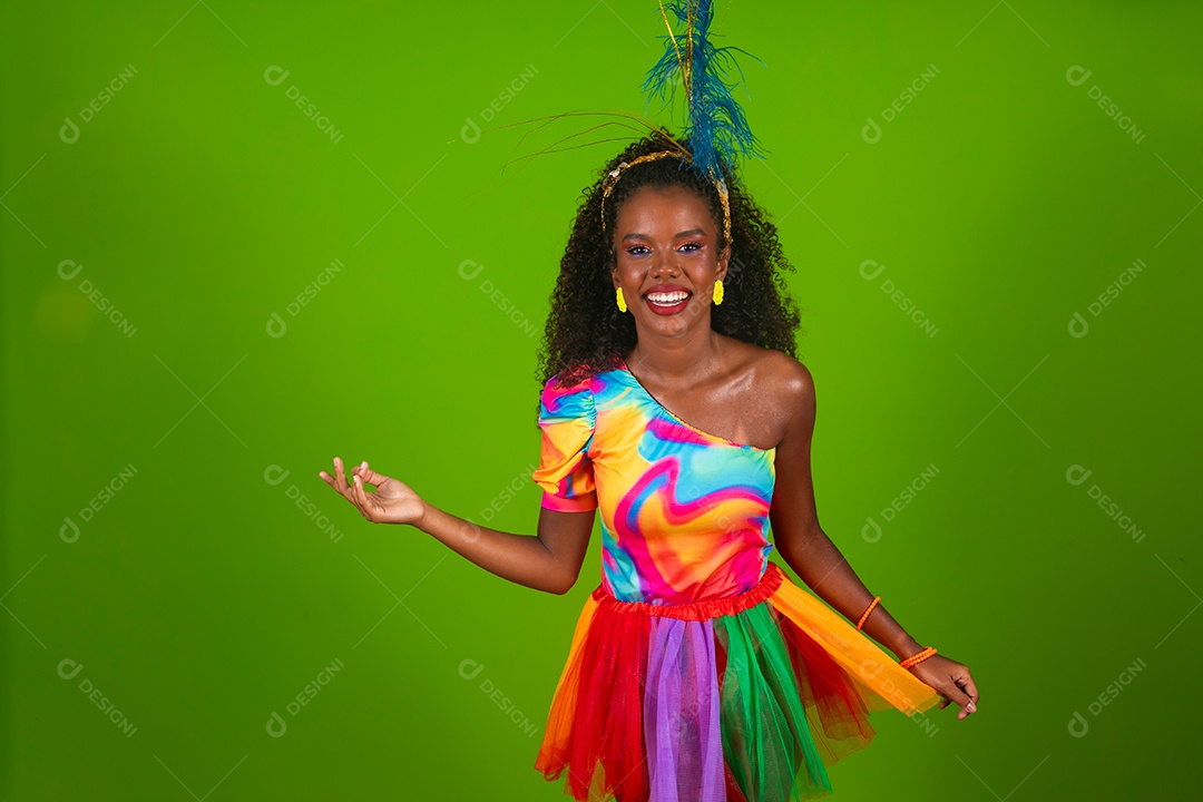 Linda morena do cabelo cacheado sorridente fantasiada sobre fundo verde isolado