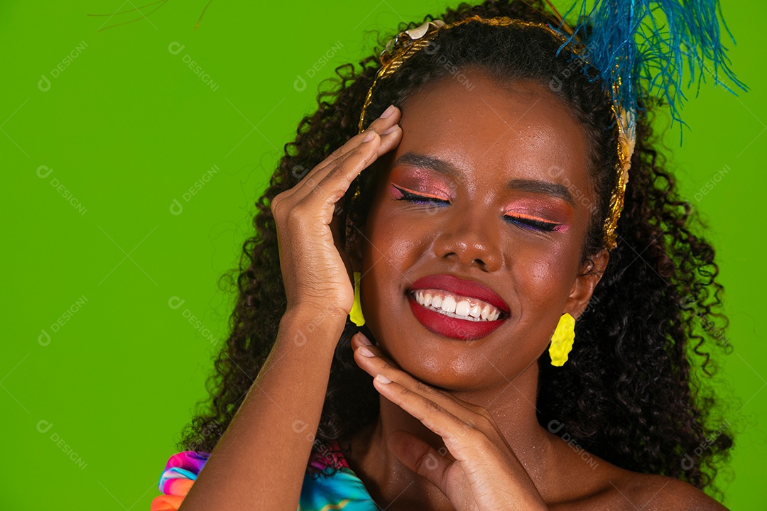 Linda morena do cabelo cacheado sorridente fantasiada sobre fundo verde isolado