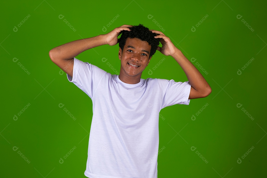 Lindo garoto negro de camisa branca sobre fundo verde isolado