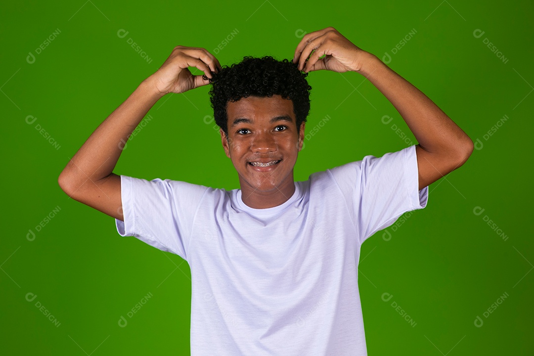 Lindo garoto negro de camisa branca sobre fundo verde isolado