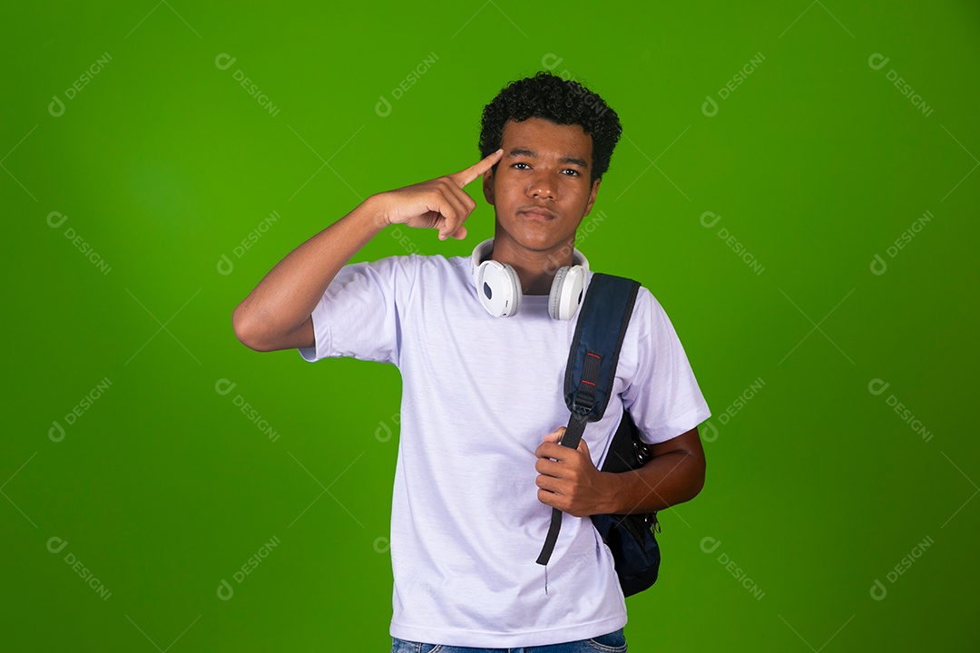 Lindo garoto negro de camisa branca usando bolsa e fone de ouvido sobre fundo verde isolado