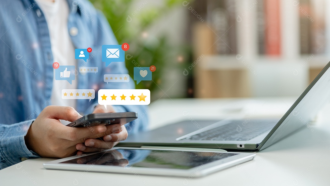 Mão de empresário mechendo em leptop e ipad ao mesmo tempo sobre fundo desfocado