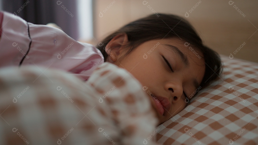 Linda menina dormindo sobre sua cama