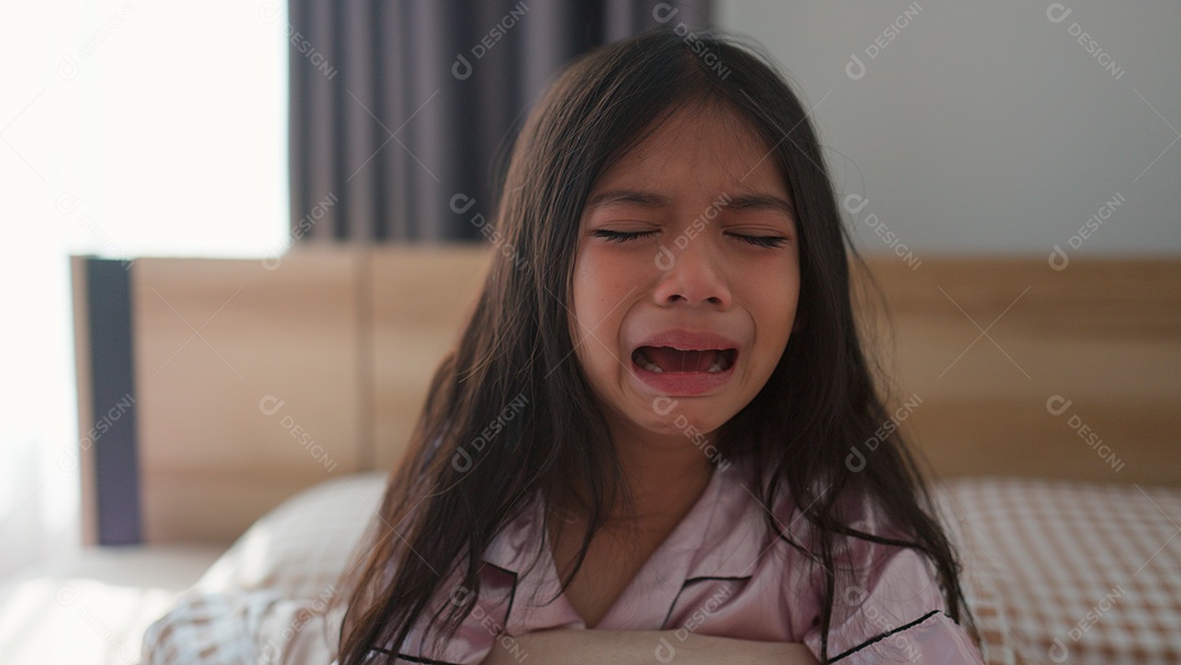 Linda menina assustada no quarto chorando com medo sobre fundo desfocado