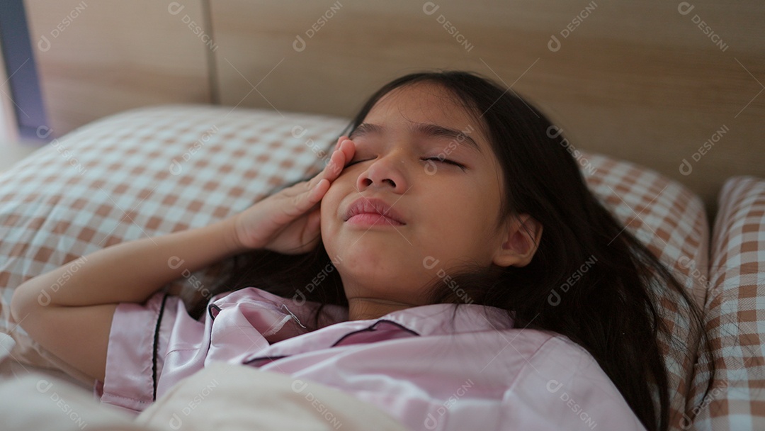 Linda menina acordando sobre sua cama