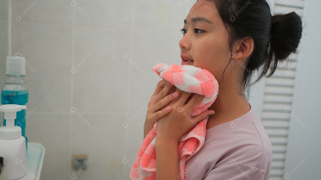 Linda menina asiática enfrente ao espelho enxugando o rosto