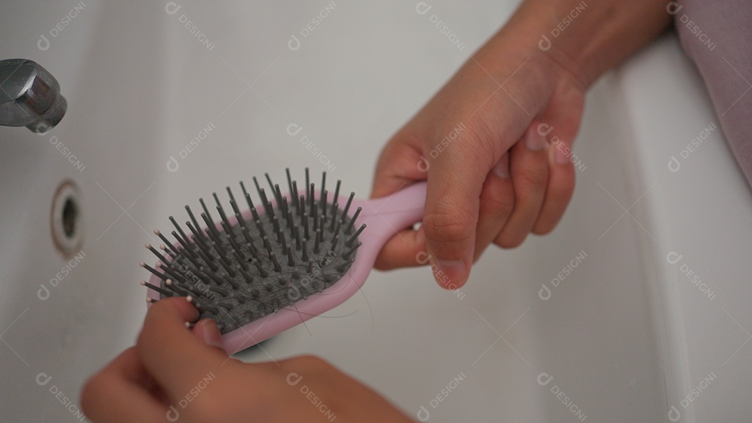 Linda menina asiática limpando escovando de cabelo sobre uma pia