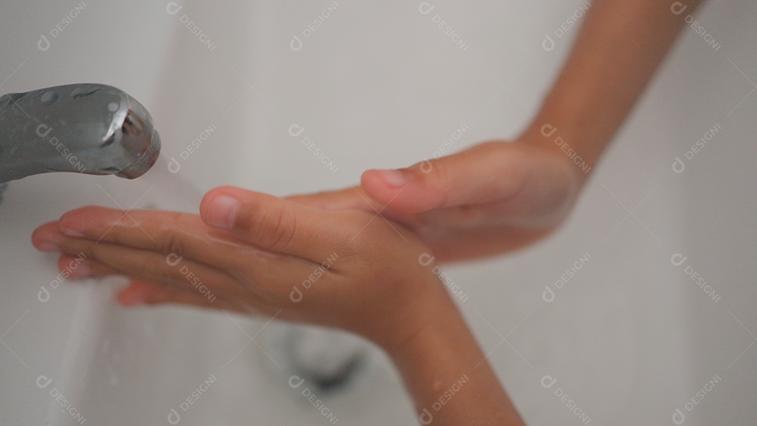 Linda menina asiática lavando as mãos sobre uma pia