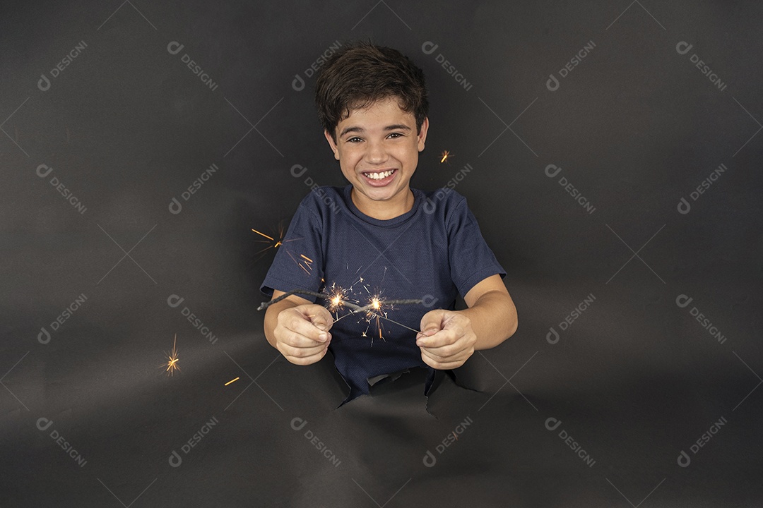 Menino segurando uma vela brilhante de papelão preto