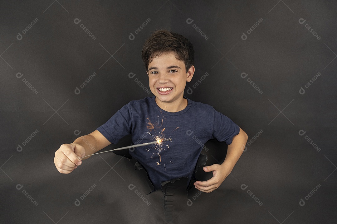 Menino segurando uma vela brilhante de papelão preto