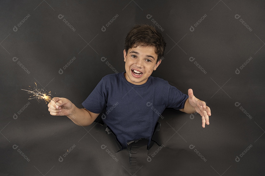 Menino segurando uma vela brilhante de papelão preto