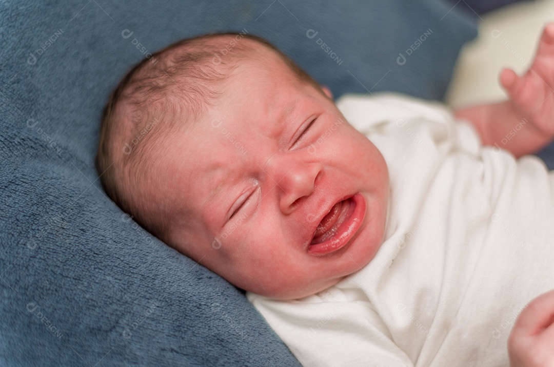 Bebê recém nascido chorando deitado na cama
