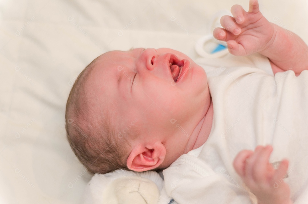 Bebê recém nascido chorando deitado na cama