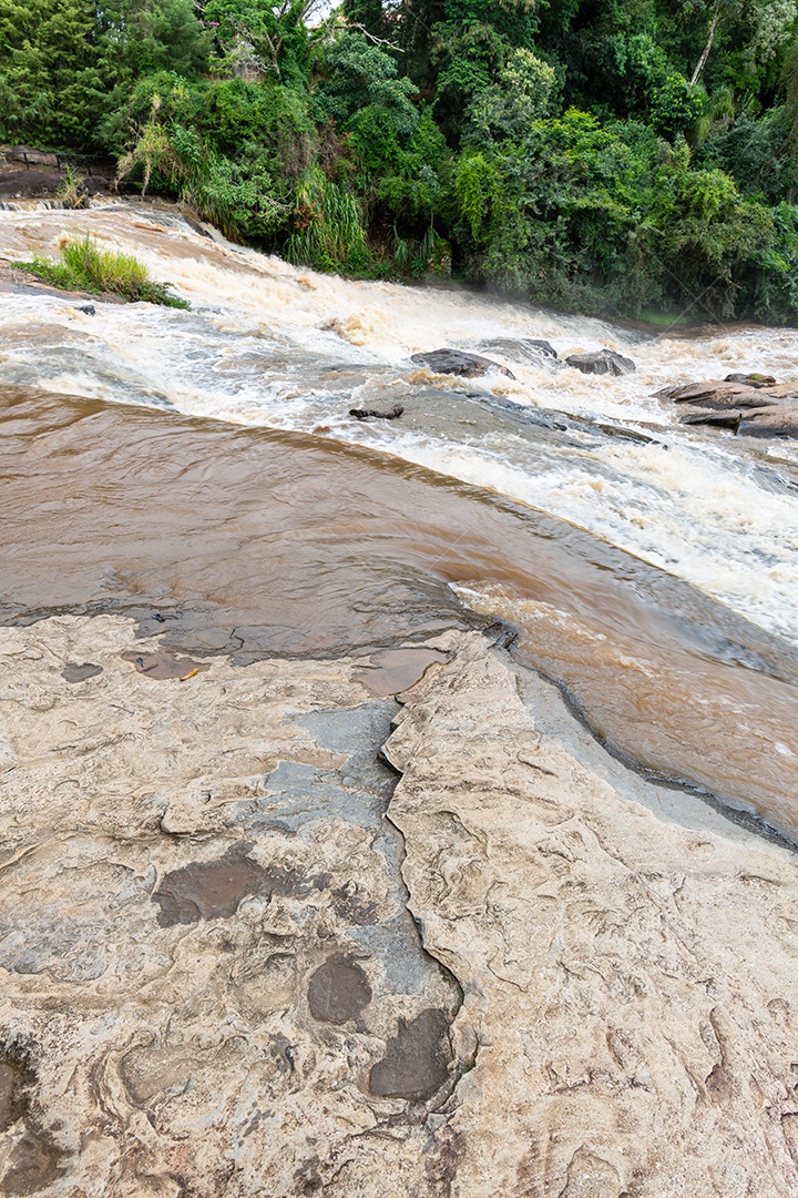 A imagem mostra uma paisagem natural com uma cachoeira