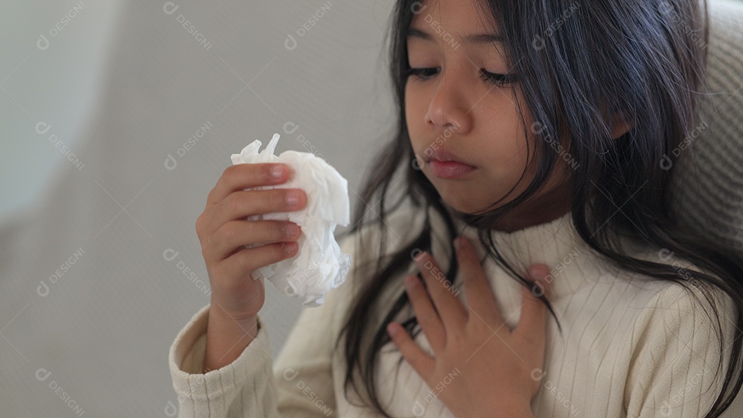 Menina asiática doente com espirros no nariz e tosse fria em lenço de papel