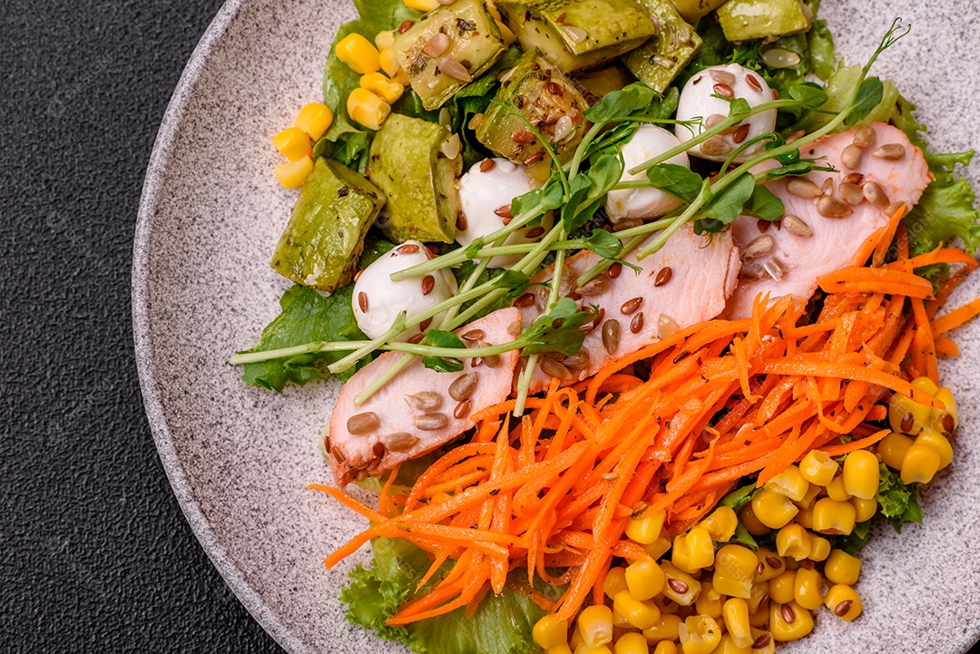 Salada fresca e sabiorosa com carne mozzarella cenouras alface e milho sobre um prato