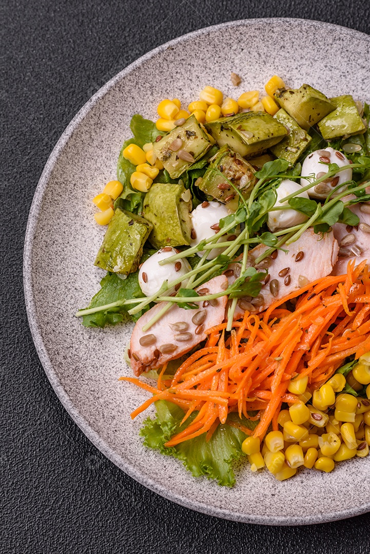 Salada fresca e sabiorosa com carne mozzarella cenouras alface e milho sobre um prato