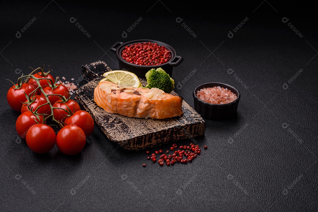 Um pedaço de salmão cozido com arroz, brócolis, sal e especiarias em um fundo de concreto escuro