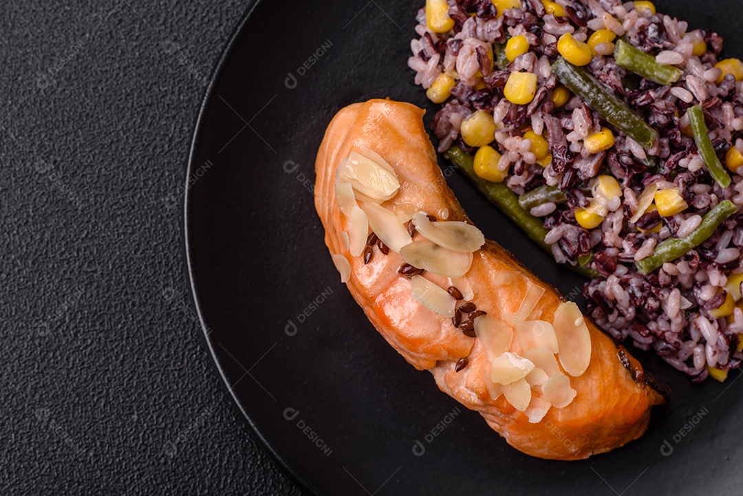 Um pedaço de salmão cozido com arroz, brócolis, sal e especiarias em um fundo de concreto escuro