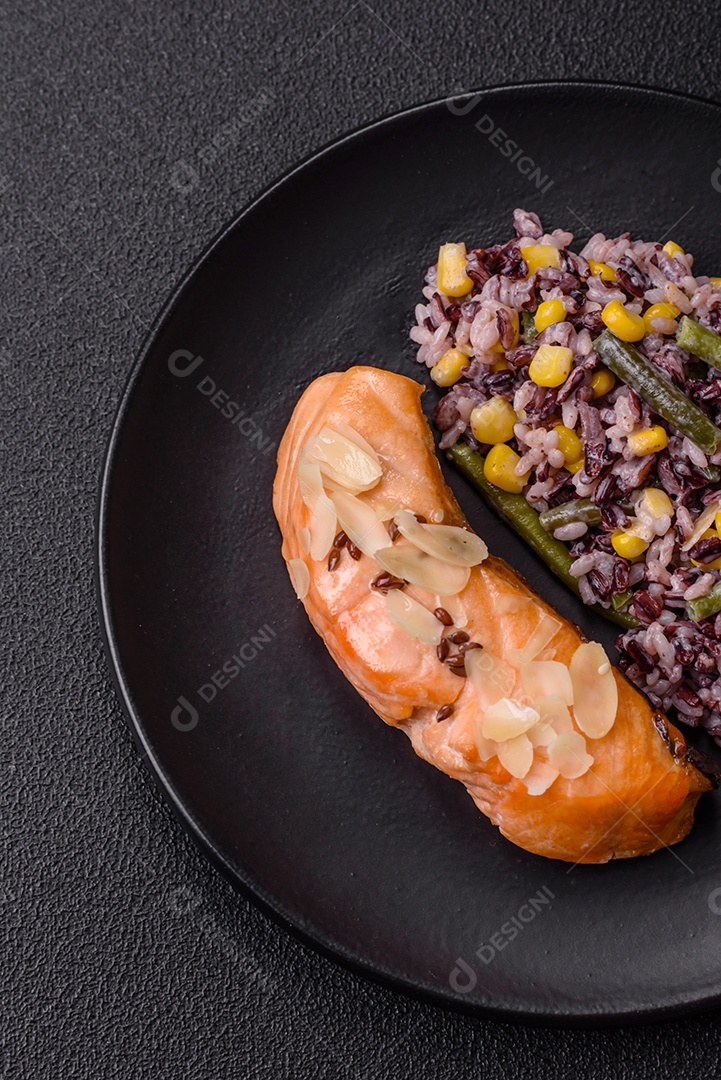 Um pedaço de salmão cozido com arroz, brócolis, sal e especiarias em um fundo de concreto escuro