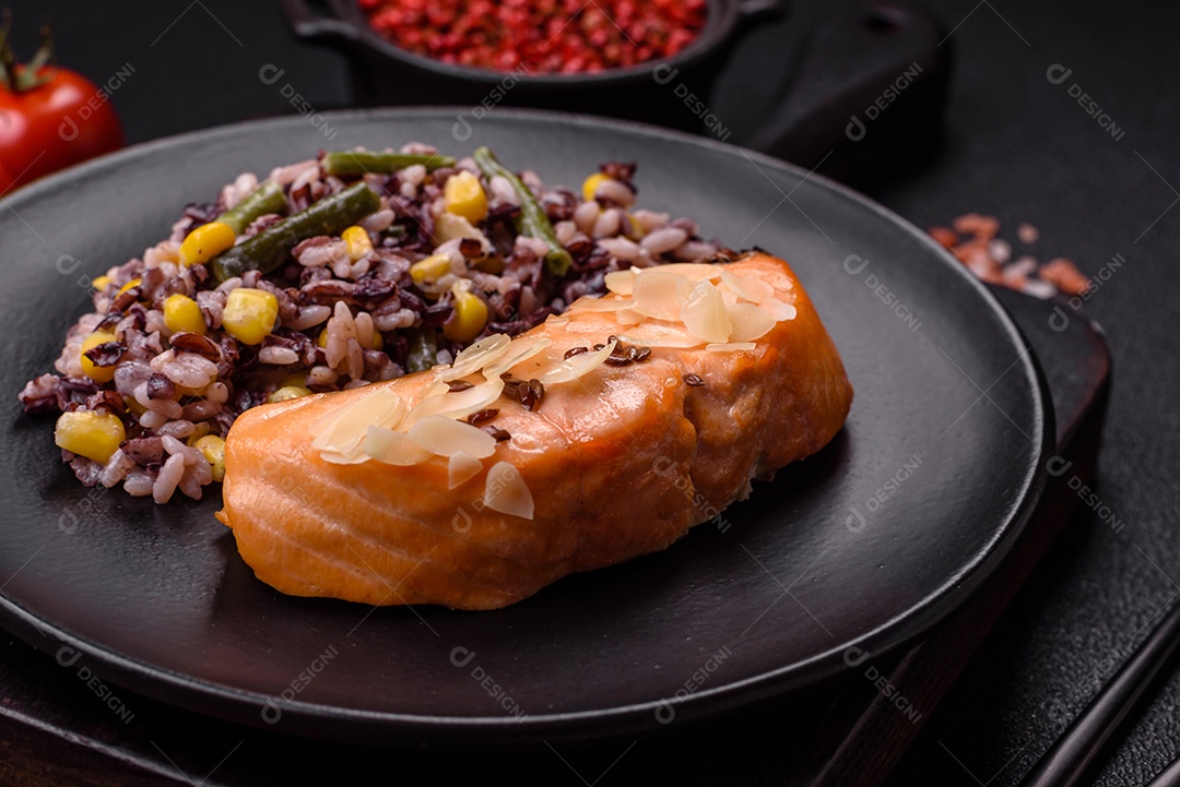 Um pedaço de salmão cozido com arroz, brócolis, sal e especiarias em um fundo de concreto escuro