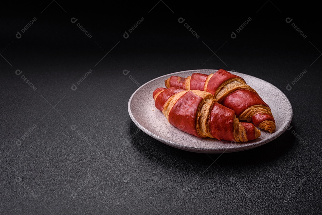 Croissant assado sobre prato em uma mesa de concreto