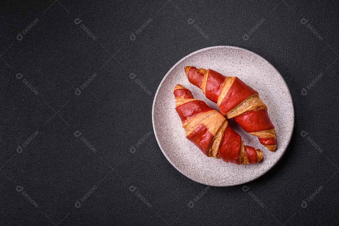 Croissant assado sobre prato em uma mesa de concreto