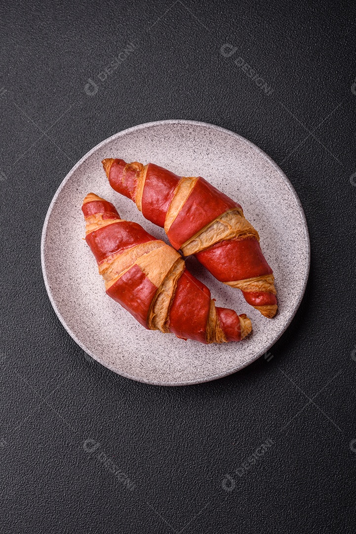 Croissant assado sobre prato em uma mesa de concreto