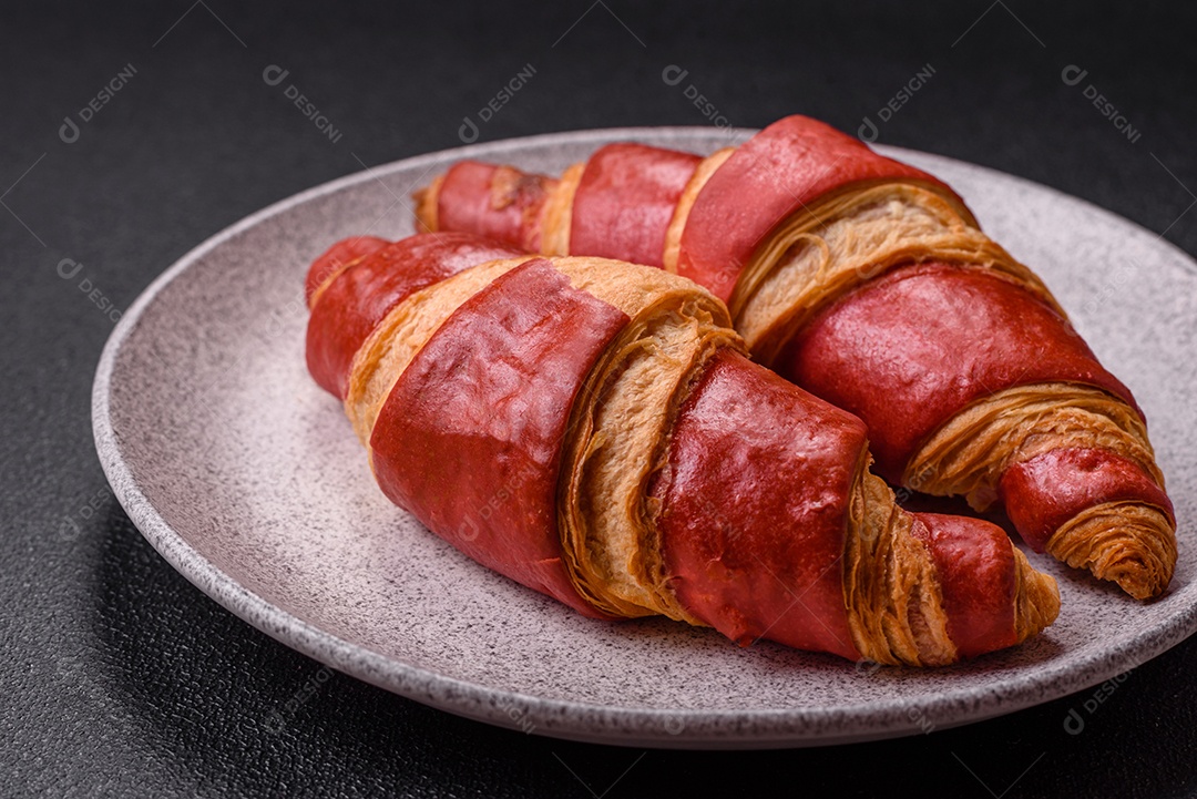 Croissant assado sobre prato em uma mesa de concreto