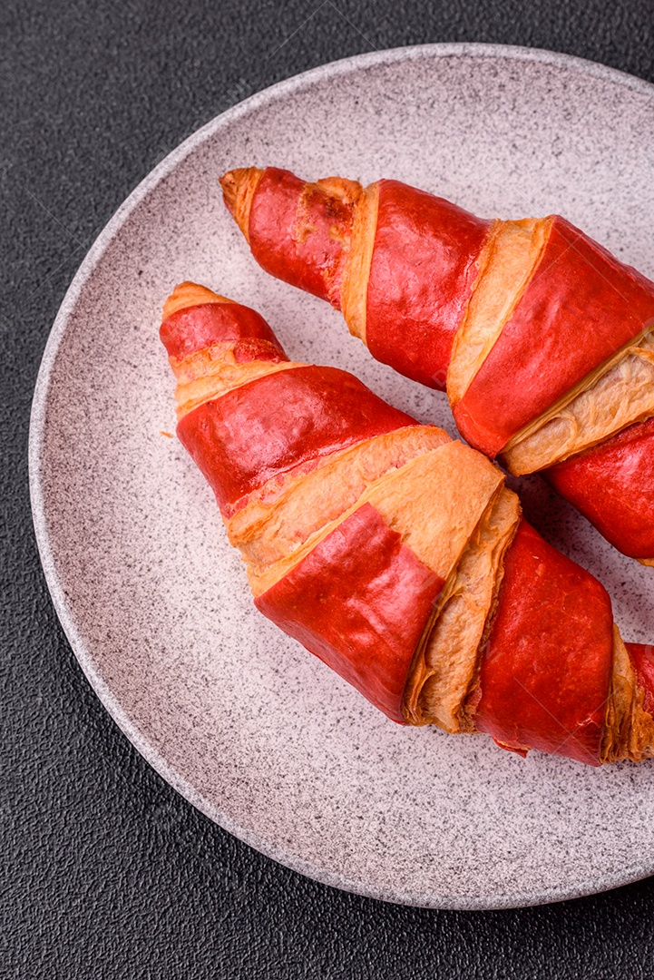 Croissant assado sobre prato em uma mesa de concreto