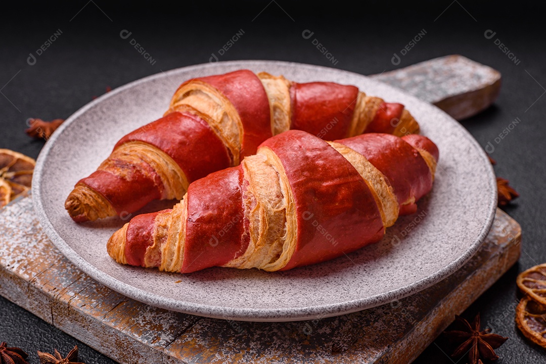 Croissant assado sobre prato em uma mesa de concreto
