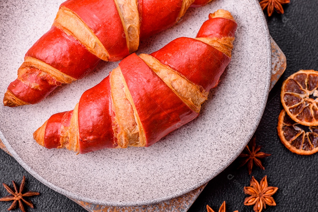 Croissant assado sobre prato em uma mesa de concreto