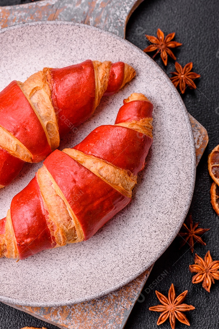 Croissant assado sobre prato em uma mesa de concreto