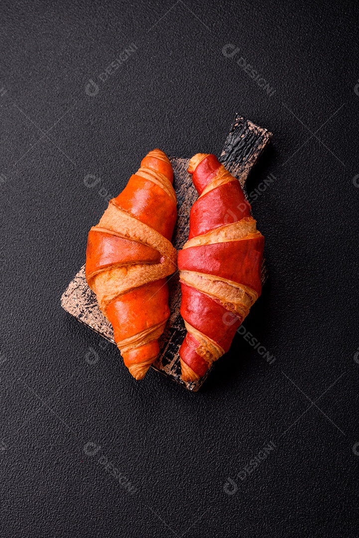 Croissant assado sobre prato em uma mesa de concreto