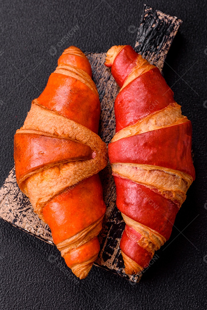 Croissant assado sobre prato em uma mesa de concreto