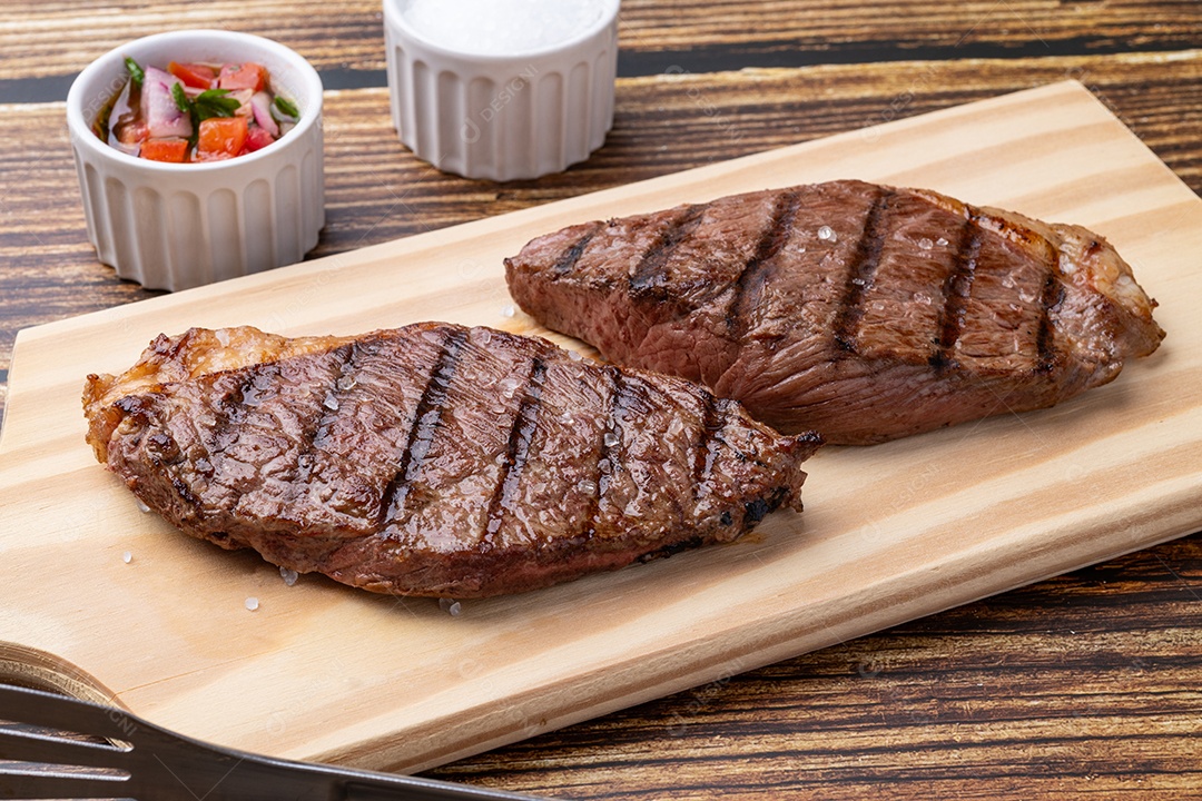 A imagem mostra dois pedaços de carne bovina grelhada