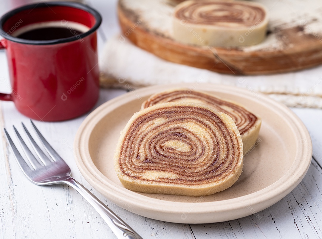 A imagem mostra um rocambole, que é um bolo em formato cilíndrico, enrolado e com recheio