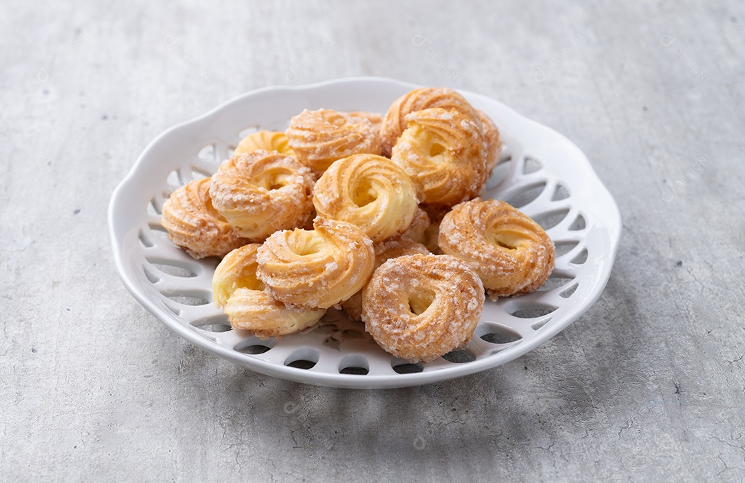 A imagem mostra carolinas, um doce feito com massa choux.