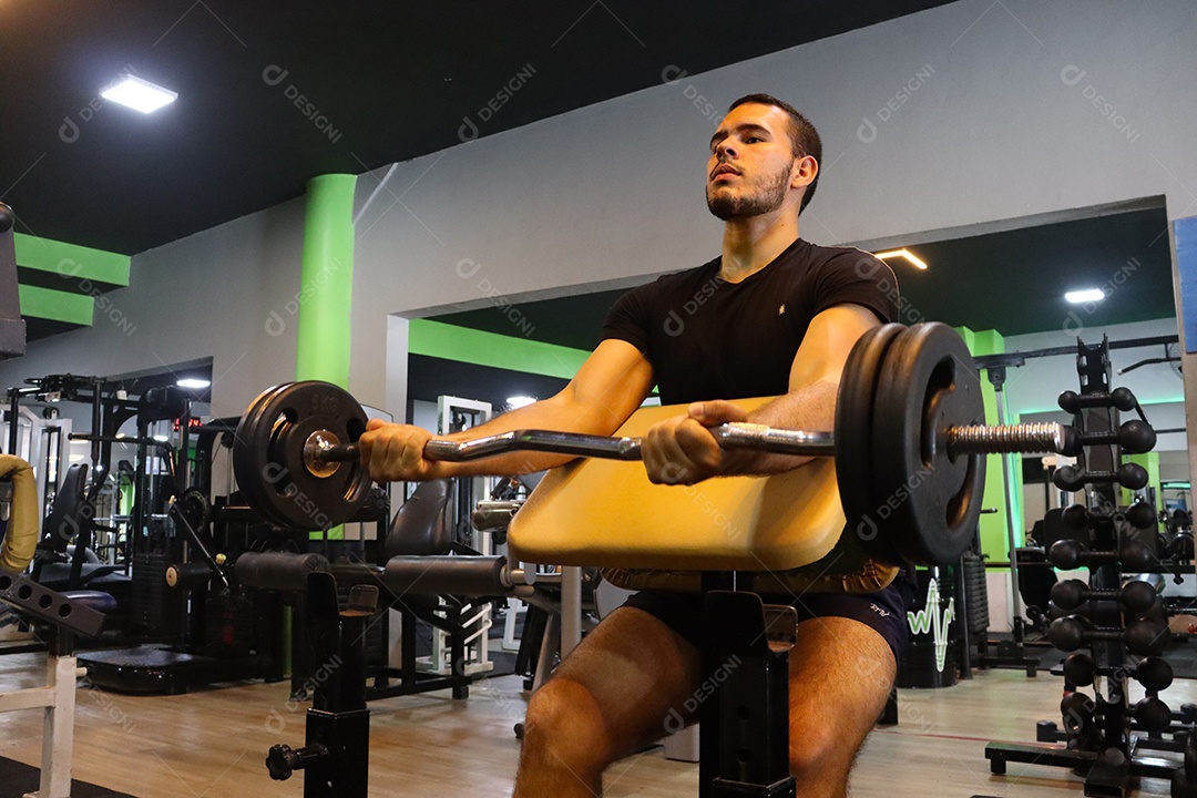 Belo homem fazendo exercicíos sobre uma academia