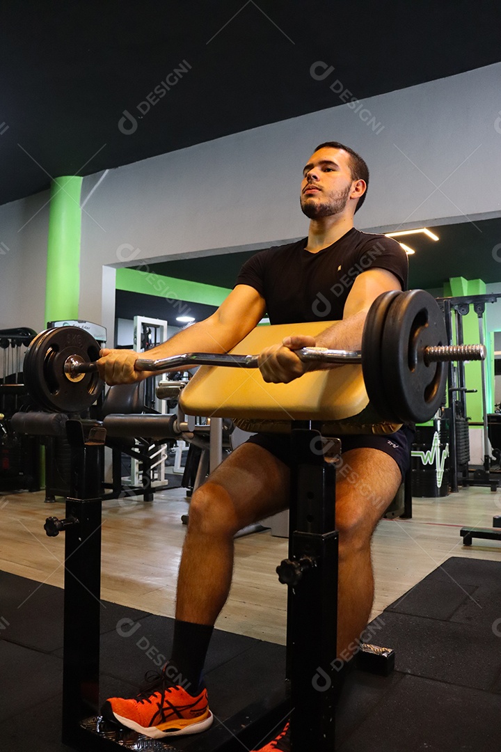 Belo homem fazendo exercicíos sobre uma academia