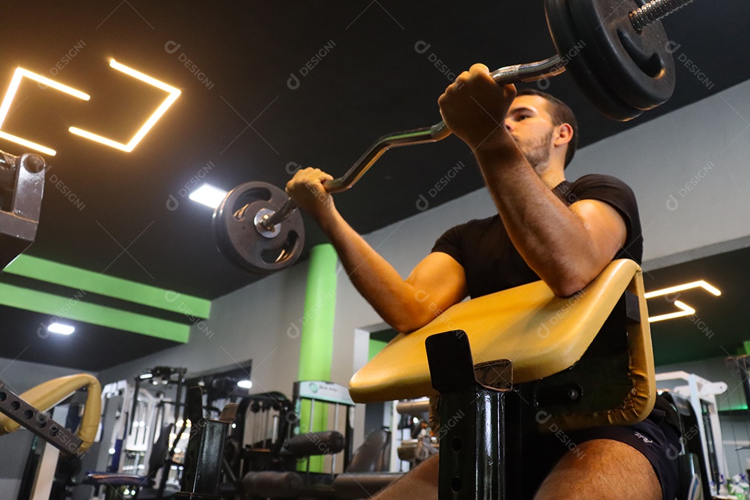 Belo homem fazendo exercicíos sobre uma academia