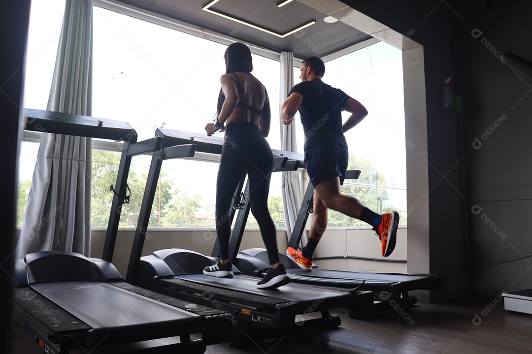 Lindo casal fazendo exercicío sobre uma academia