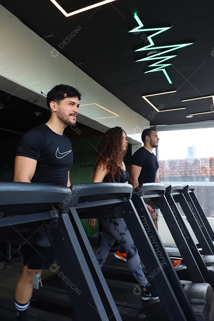 Lindas pessoas fazendo exercicíos sobre uma academia